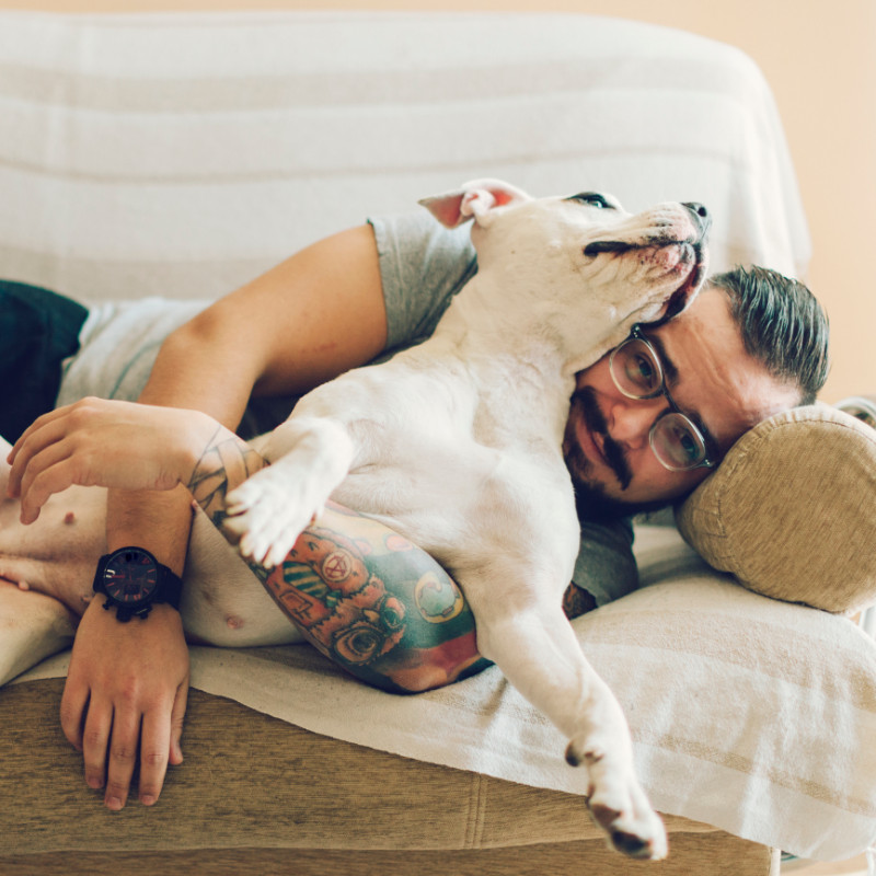 A man with tattoo and his dog