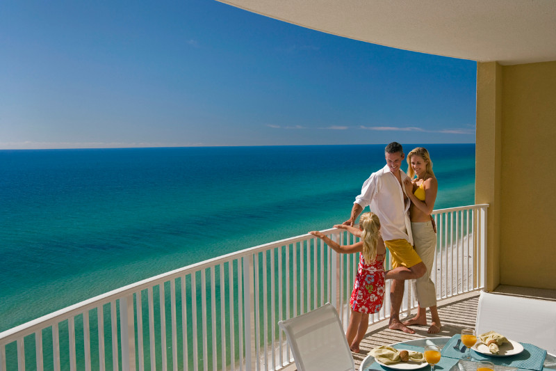 Family of three on the balcony by the sea